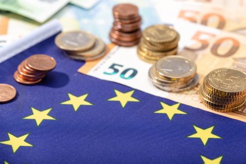 European Union financial stimulus on coronavirus Covid-19 pandem European Union financial stimulus on coronavirus Covid-19 pandemic concept. European Union flag with euro bills and coins